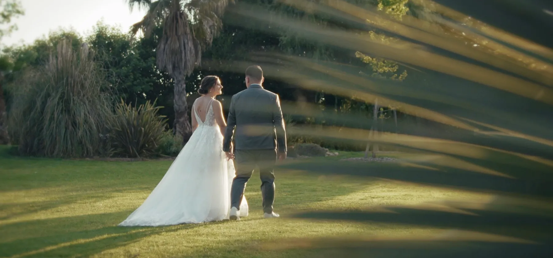 Les mariés marchent dans un jardin au soleil, filmés par Peak Prod